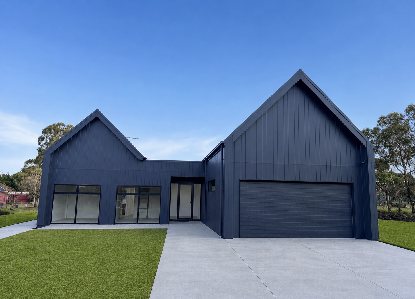 Completed dark navy new home build with double garage and landscaped frontage